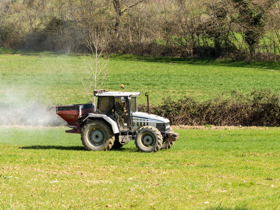 Tractor working spreading fertiliser