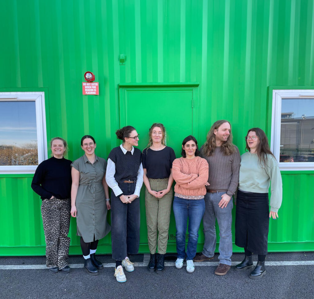 team photo outside of container.